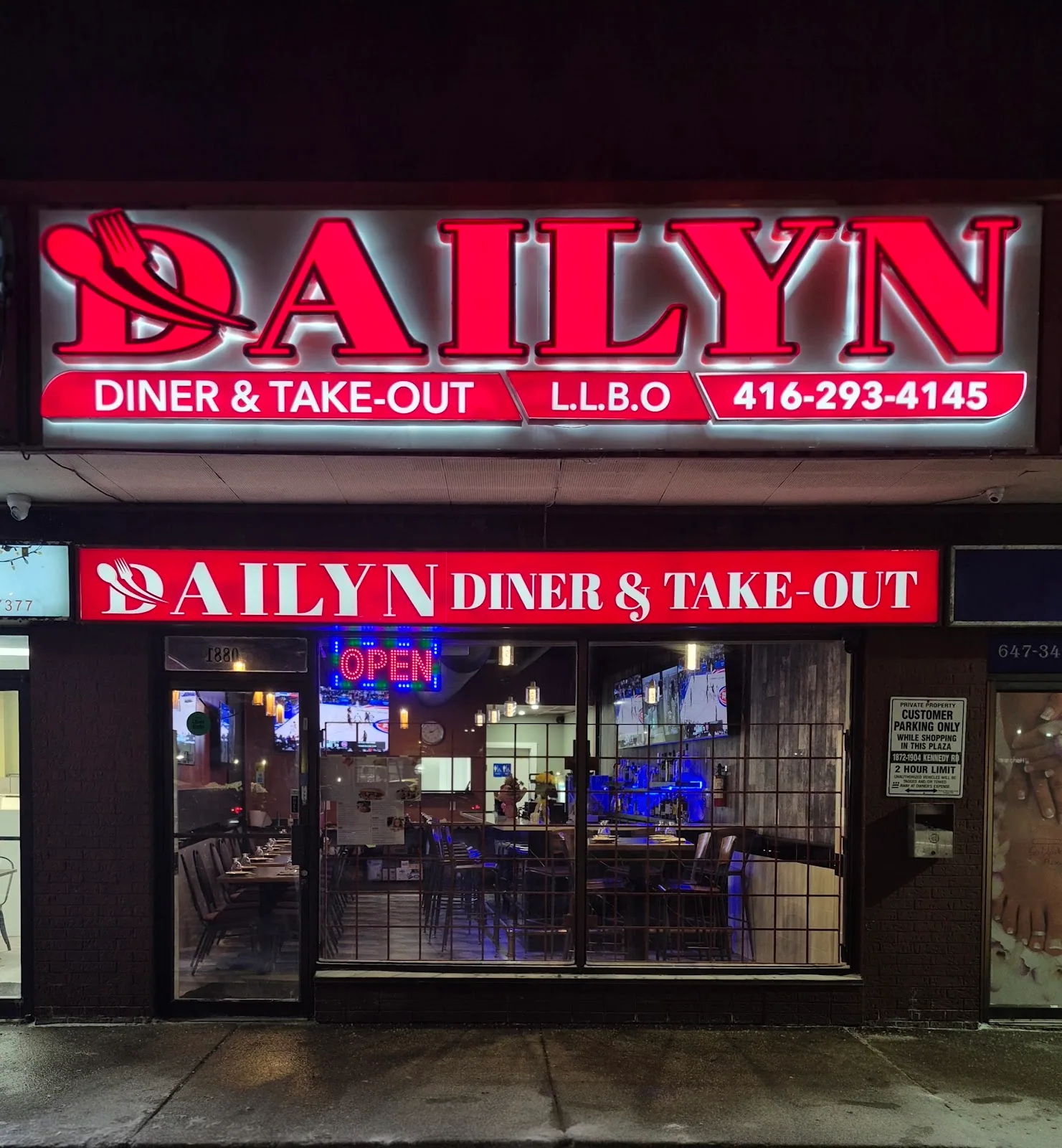 The Dailyn Diner & Take-Out storefront lit up in red neon at night on Kennedy Road